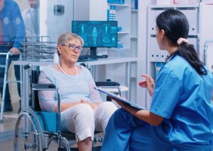 Photo of a medical professional discussing neurological conditions with a patient sitting in a wheelchair